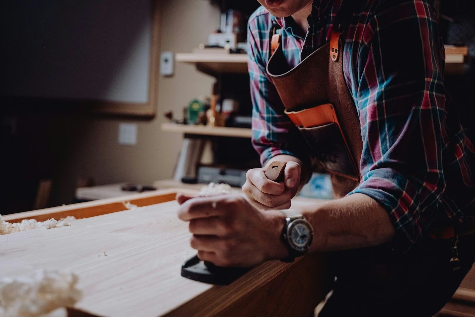 Handwerker bearbeitet Holz mit dem Hobel